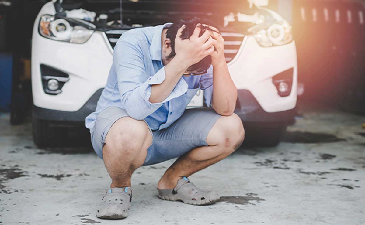 What Causes a Headache After a Car Accident and How Its Treated Frustrated man squatting near broken car. - What Causes a Headache After a Car Accident and How Its Treated